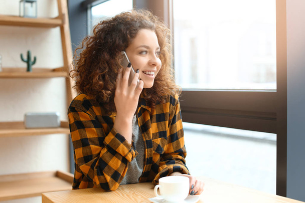 Mujer joven hablando en el teléfono móvil en interiores
 - Foto, Imagen