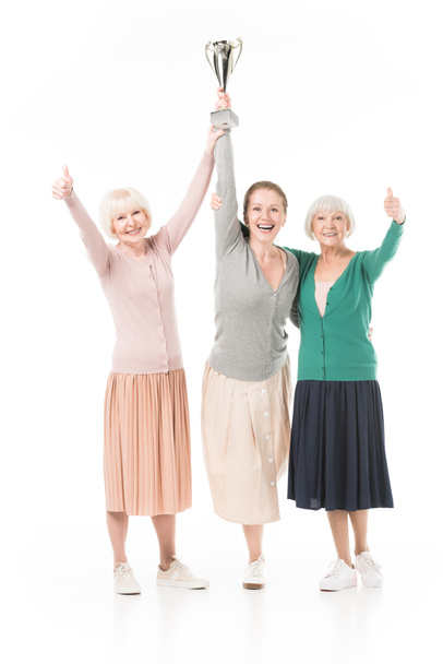 drei lächelnde stilvolle Frauen feiern mit Pokal isoliert auf Weiß - Foto, Bild