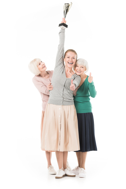 glücklich stylische Frauen zeigen Daumen nach oben Geste und feiern mit Trophäe isoliert auf weiß - Foto, Bild