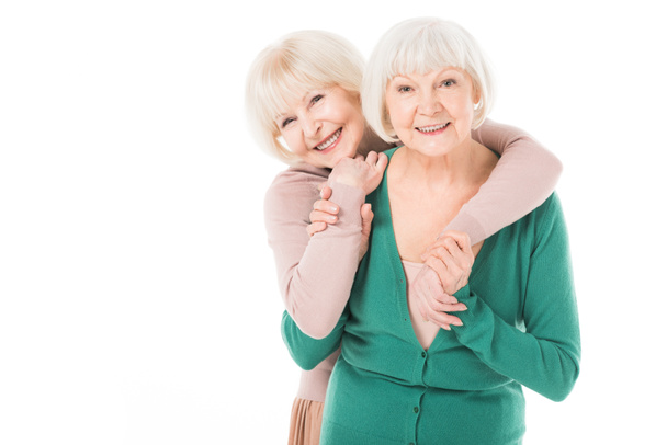 Deux femmes élégantes seniors étreignant isolé sur blanc
 - Photo, image