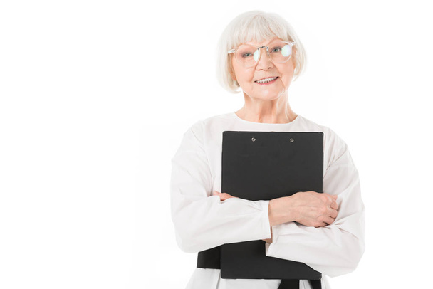 Stylish senior businesswoman in eyeglasses with clipboard in hands isolated on white - Photo, Image