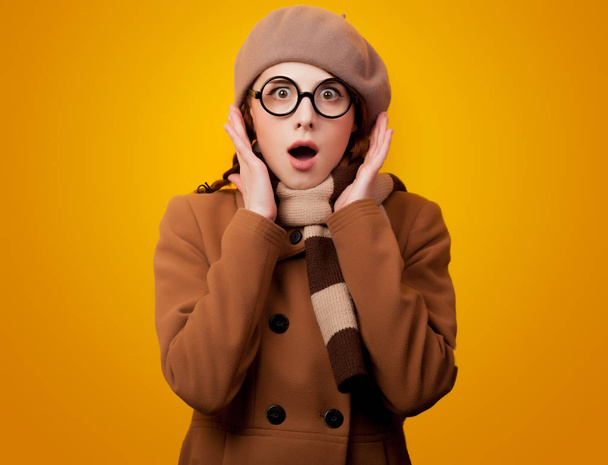 Retrato de jovem nerd redehad menina no casaco e óculos no fundo amarelo
  - Foto, Imagem