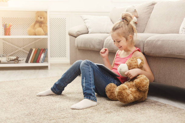 Malá holčička s tabletem, sedí na podlaze doma - Fotografie, Obrázek