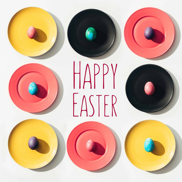frame of easter eggs on colorful plates with happy easter lettering - Photo, Image