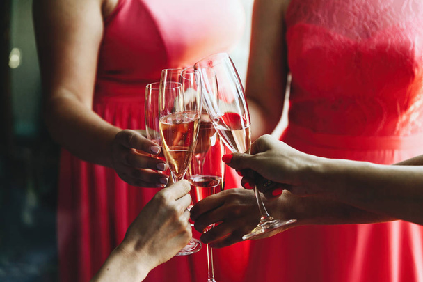 Women in pink dresses clang glasses with champagne - Фото, изображение