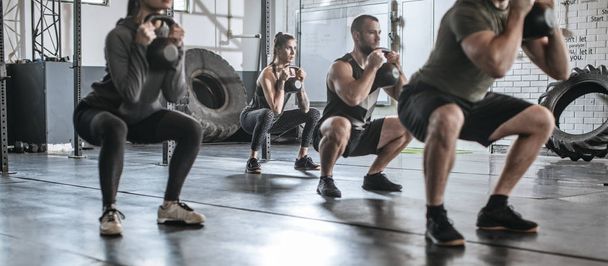 Sportsmen and Sportswomen Lifting Weights at Gym - Фото, изображение