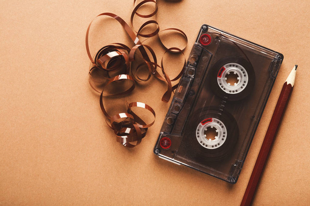 Cassetta vintage e matita per riavvolgere il nastro su sfondo marrone
 - Foto, immagini