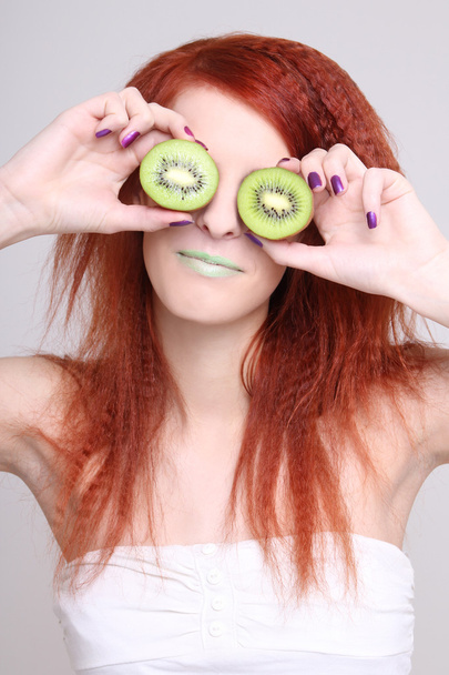 młoda kobieta trzymając Owoce kiwi na oczy - Zdjęcie, obraz