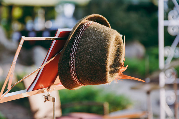 Perinteinen hattu koristeltu nauhoilla ja höyhenillä osa Saksan kansallispukua Oktoberfestin juhlaa varten roikkuu musiikkitelineessä festivaalin muistiinpanoja varten.
 - Valokuva, kuva