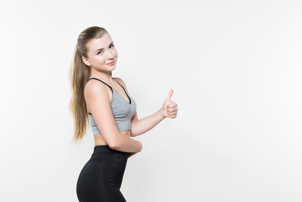 Sportvrouw tonen duim geïsoleerd op wit - Foto, afbeelding