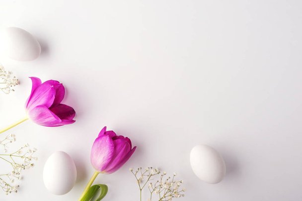 Flowers and white eggs on a white background. - Фото, изображение