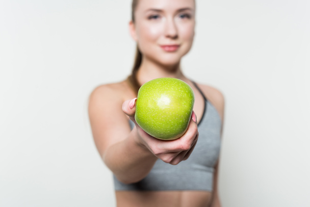 Apple in hand of fitness girl isolated in white - Foto, immagini