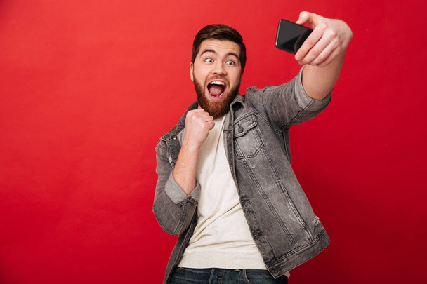 Onnellinen huutaa mies tekee selfie älypuhelimeen suu auki
 - Valokuva, kuva