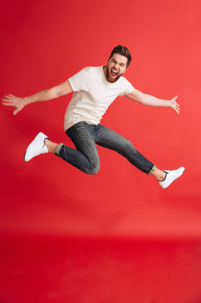 Excited emotional bearded man jumping - Fotoğraf, Görsel