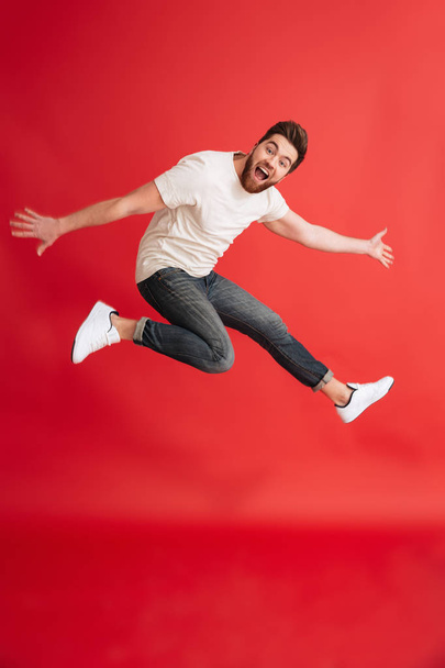 Excited emotional bearded man jumping - 写真・画像