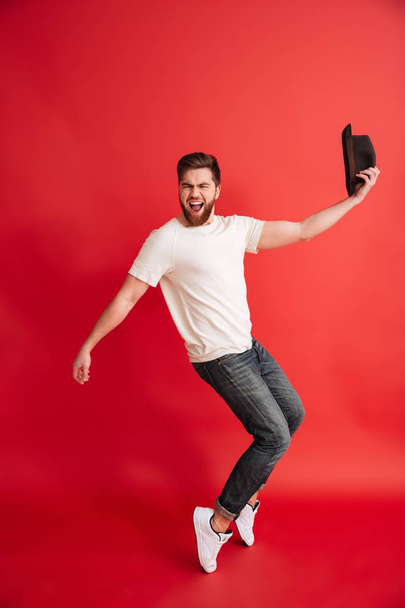 Excited bearded man dancing wearing hat. Looking camera - Photo, Image