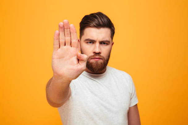Portrait of a serious bearded man showing stop gesture - Foto, imagen
