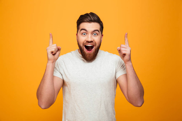 Portrait of a happy bearded man pointing fingers up - Фото, зображення