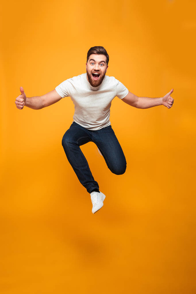 Full length portrait of an excited bearded man jumping - Foto, Imagem