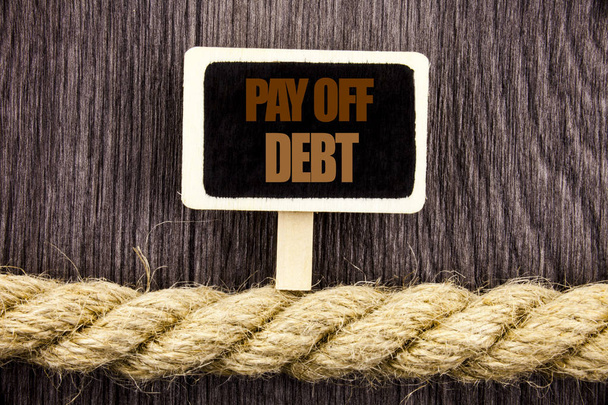 有料のオフ負債を示す概念記述テキスト。事業写真展示アラームに払って債務金融信用の貸付け金手形黒板がぶら下がっている木の背景にロープに書かれています。 - 写真・画像