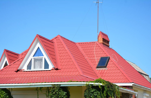 Κλείστε επάνω σε κόκκινο μεταλλικής στέγης με σοφίτα, παράθυρο φεγγιτών στεγών guttering περιοχή πρόβλημα συστήματος αγωγών. - Φωτογραφία, εικόνα