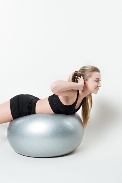 Young fit girl on exercise ball isolated on white - Foto, Imagen