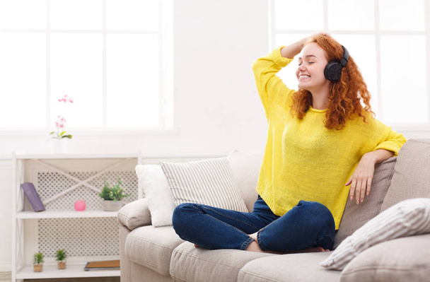 Happy woman enjoying her favorite song in earphones - Photo, Image