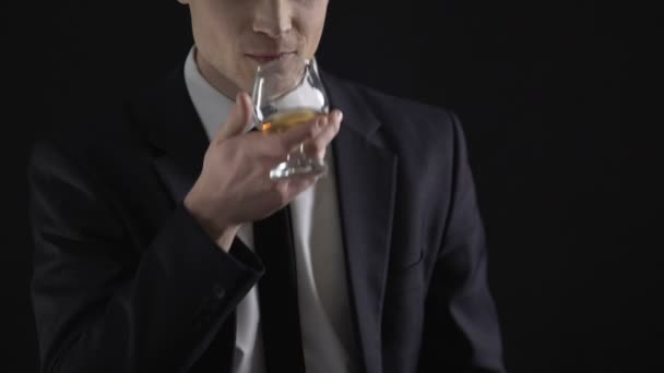 Businessman holding dollar cash and drinking cognac, celebrates income increase - Materiał filmowy, wideo