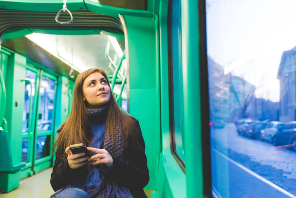 giovane donna all'aperto utilizzando smartphone che viaggiano con i mezzi pubblici
  - Foto, immagini