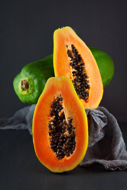 fresh ripe papaya on a napkin and slate plate kitchen table can be used as background - Valokuva, kuva