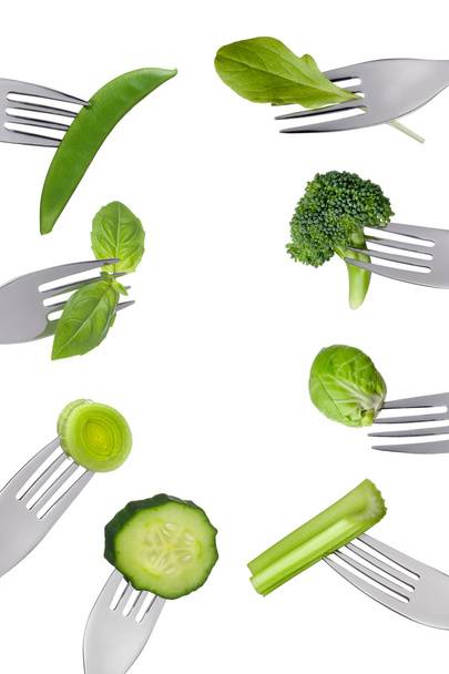 Border of fresh green vegetables isolated on forks - Photo, Image
