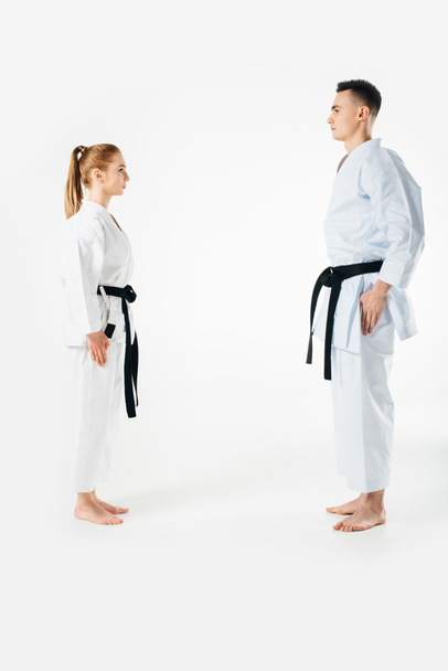 luchadores de karate de pie y mirándose aislados en blanco
 - Foto, Imagen