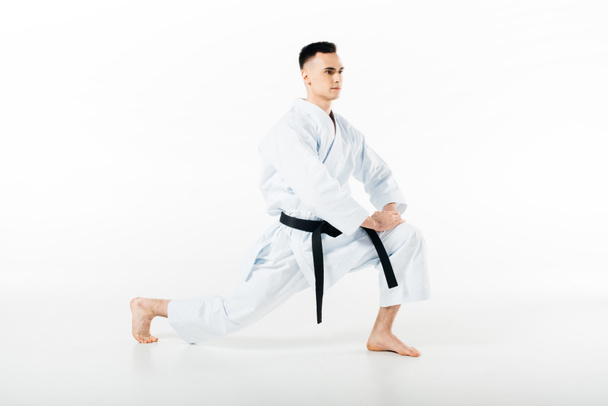 mannelijke karate vechter benen geïsoleerd op witte rekken - Foto, afbeelding