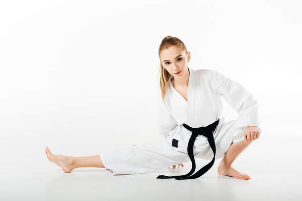 bojovník karate ženské strečink a při pohledu na fotoaparát izolované na bílém - Fotografie, Obrázek