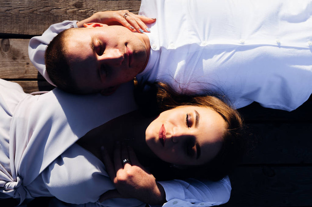 vista superior de una pareja que se encuentra en una superficie de madera y cerró los ojos
 - Foto, imagen