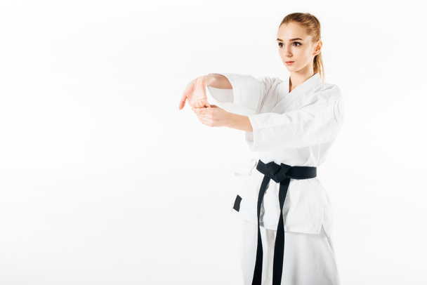 жіночий карате боєць розтягує руки ізольовані на білому
 - Фото, зображення