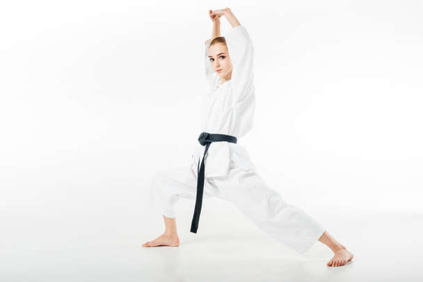 female karate fighter stretching isolated on white - 写真・画像