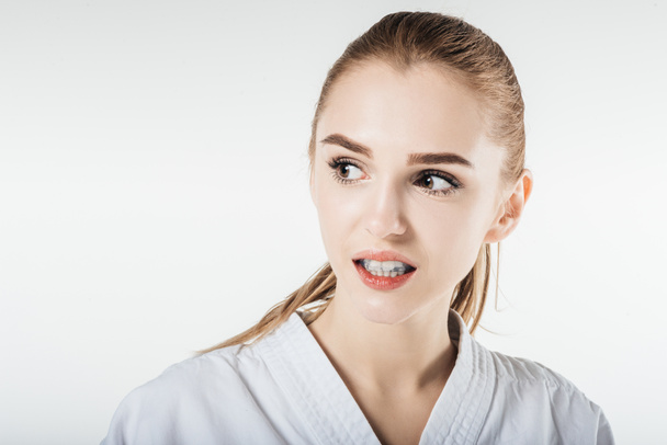 combattant de karaté féminin regardant loin avec protège-dents isolé sur blanc
 - Photo, image