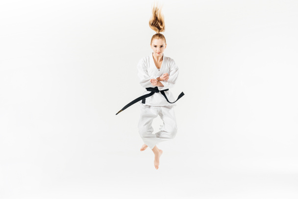 female karate fighter jumping isolated on white - Fotó, kép