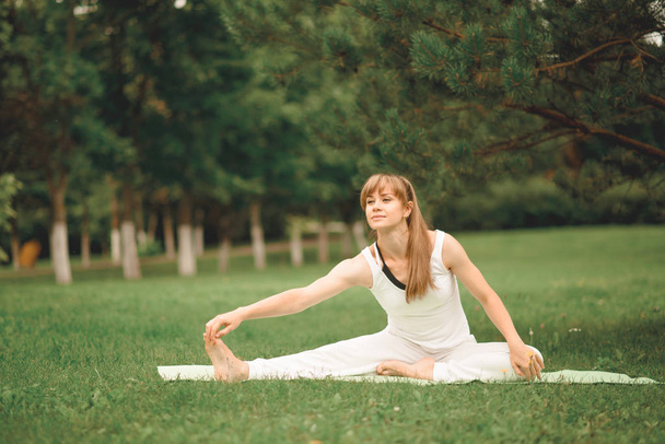 Young woman does Yoga in the park - Valokuva, kuva