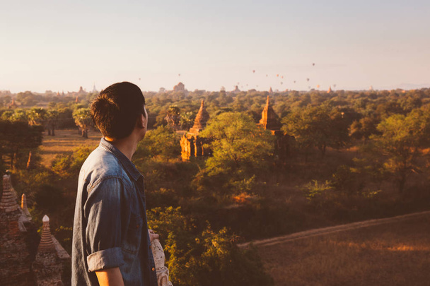 Silhouette of young male backpacker watching sunset and pagoda in Bagan, Burma - Foto, Imagem
