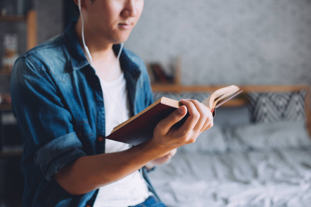 Mladý muž čtení knih v útulném obýváku - Fotografie, Obrázek