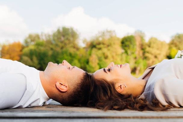 Un homme et une femme allongés sur la surface en bois une tête à tête et s
 - Photo, image