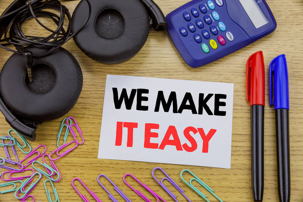 Scrivere un testo che mostri We Make It Easy. Business concept for Help Quality Solution scritto su carta appiccicosa sullo sfondo di legno. Con calcolatrice e pennarello e cuffie
 - Foto, immagini
