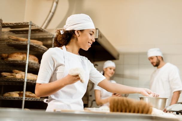 equipo multiétnico de panaderos que trabajan juntos en la fabricación de panadería
 - Foto, Imagen