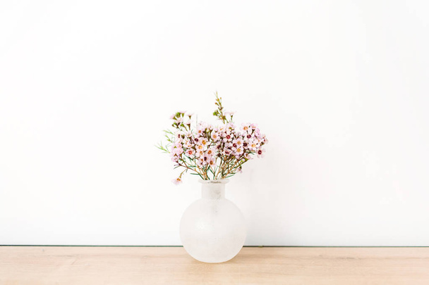 Flores silvestres en jarrón sobre fondo blanco. Vista frontal composición mínima
. - Foto, imagen