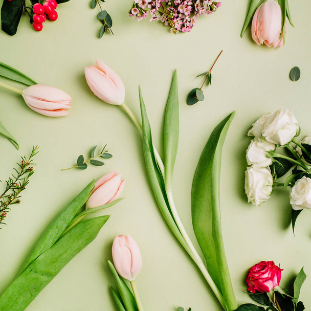 Flowers pattern of tulips, roses, hypericum flower on green background. Flat lay, top view spring concept. - Photo, Image