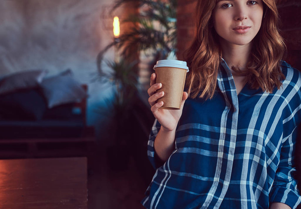 Portret van een jonge hipster meisje drinkt koffie in de ochtend met een loft interieur. - Foto, afbeelding