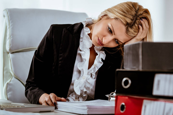 Молодая уставшая деловая женщина беспокоится сидя
  - Фото, изображение