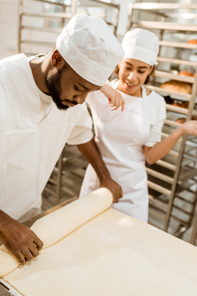 Afryki amerykański piekarzy pracę z wałeczków ciasta przemysłowych pieczenia produkcji - Zdjęcie, obraz